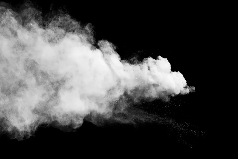 White smoke plume bursting across black background