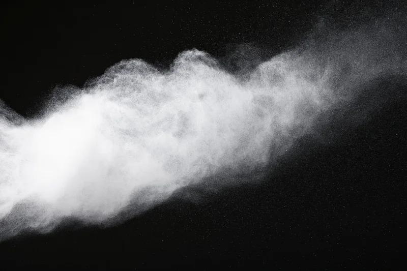 White powder exploding in mid-air against black background