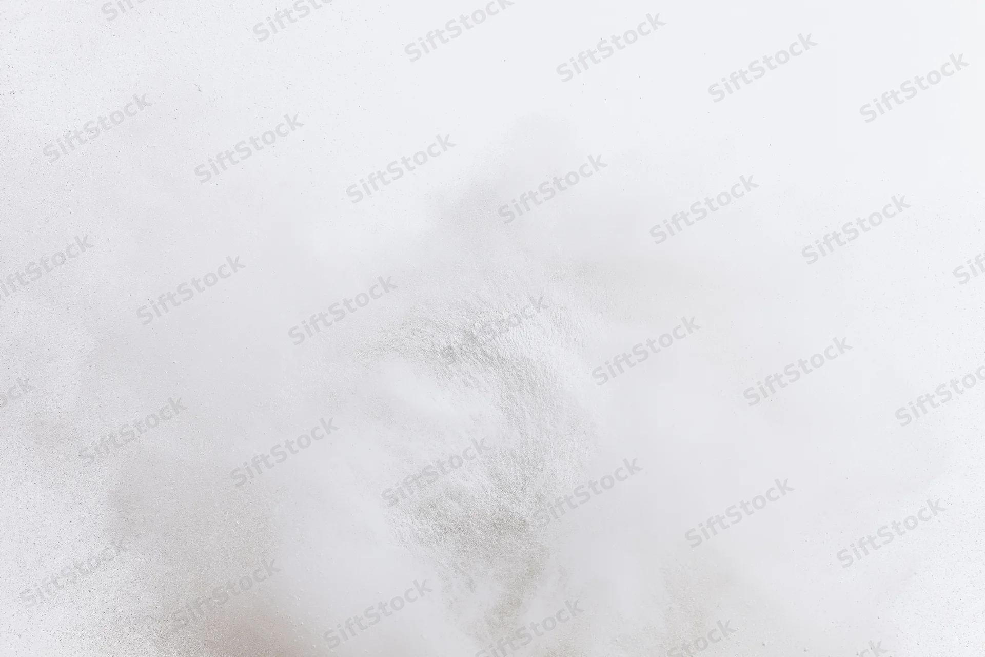 White powder bursting into fine dust cloud mid-air against pure white background