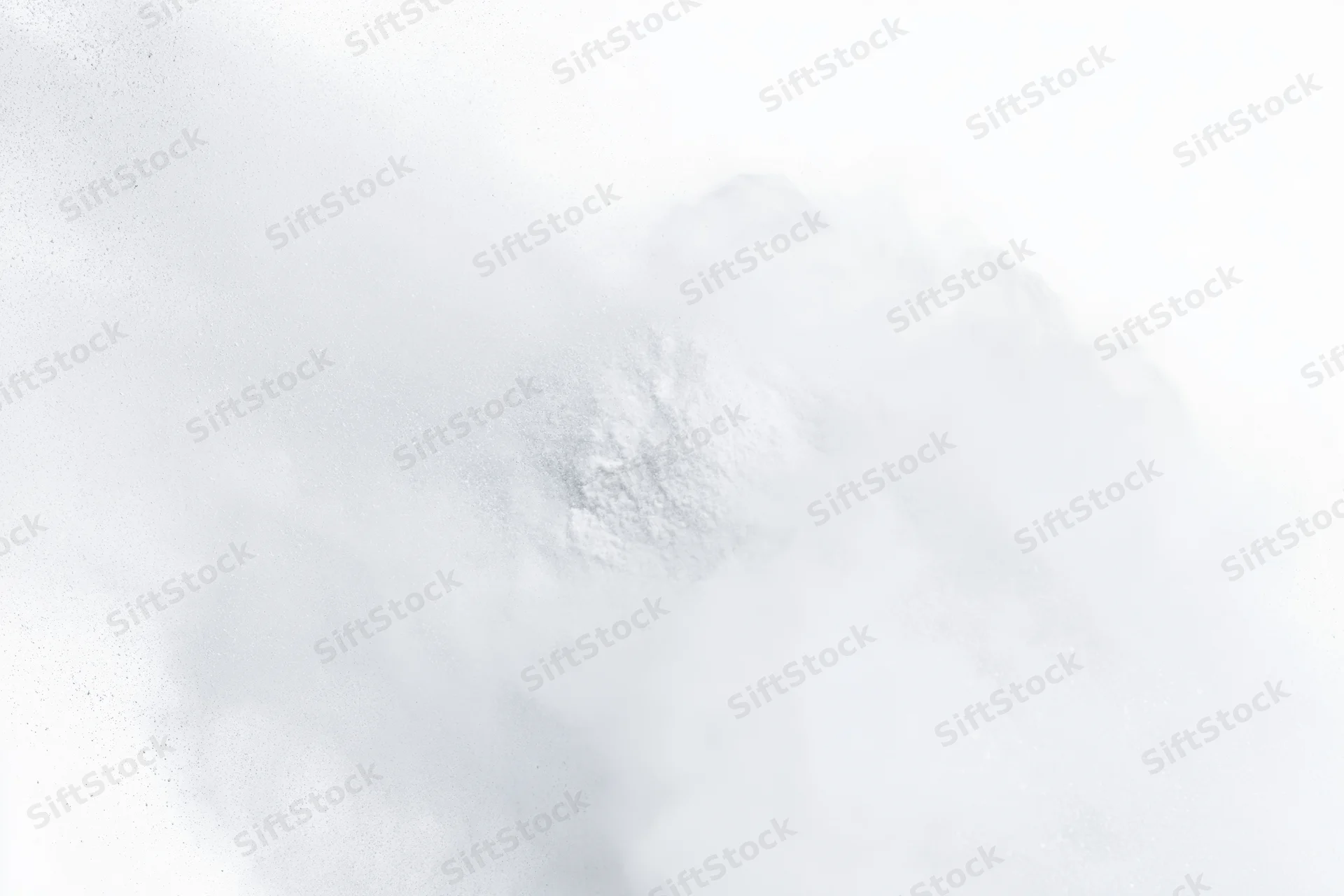 White powder bursting into airborne cloud against pure white background