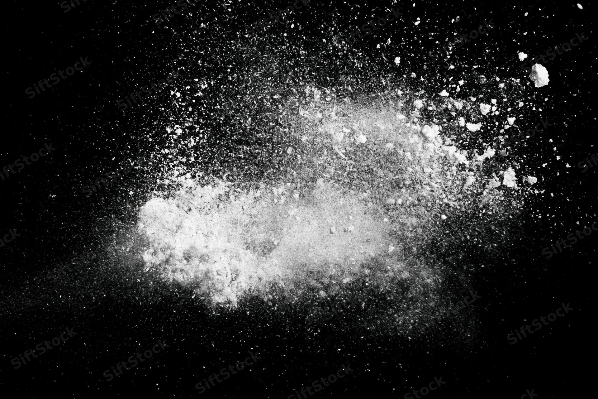White powder exploding midair against black background