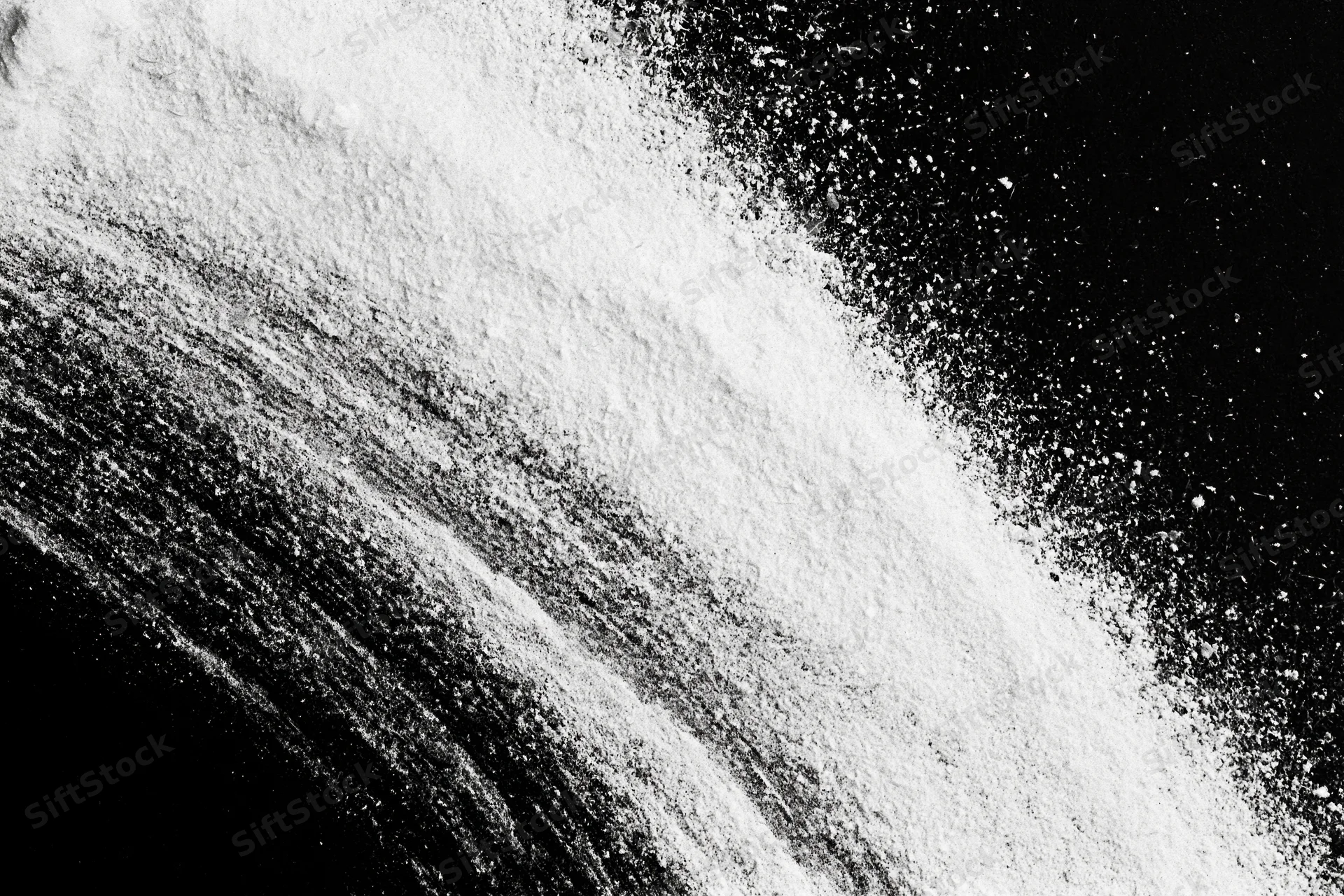 White powder scattered diagonally across black surface
