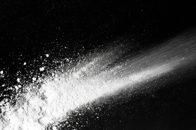 White powder scattered diagonally across black surface