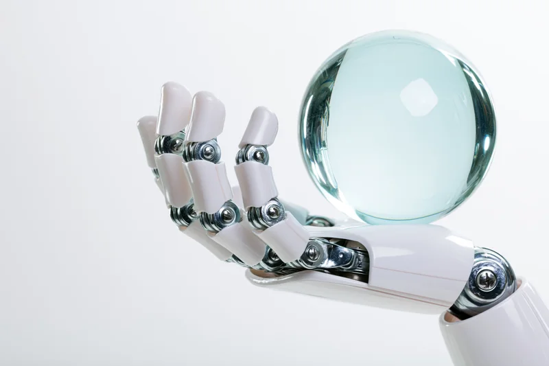 Robotic hand holding a transparent glass sphere against a white background