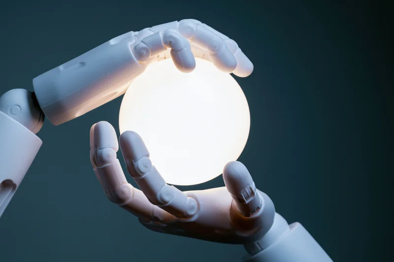 Robotic hands cradling a glowing orb against a dark background
