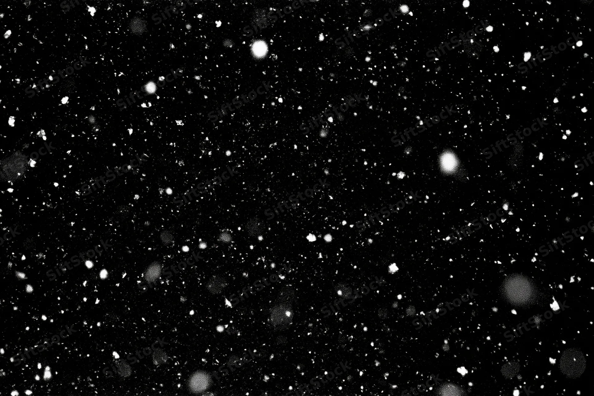 White snow particles falling against a black background