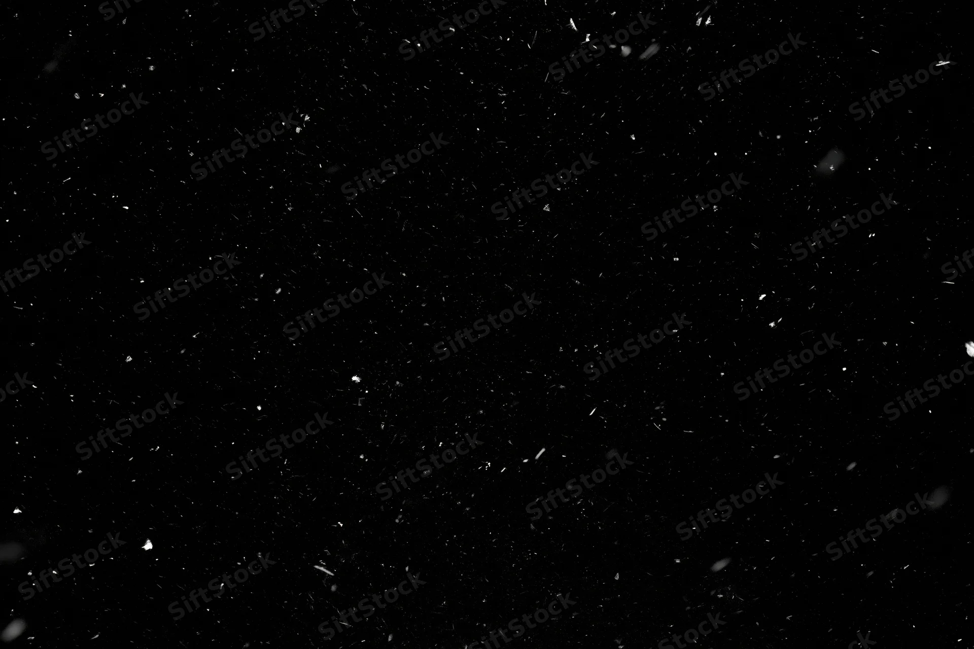 Snowflakes falling against a black background
