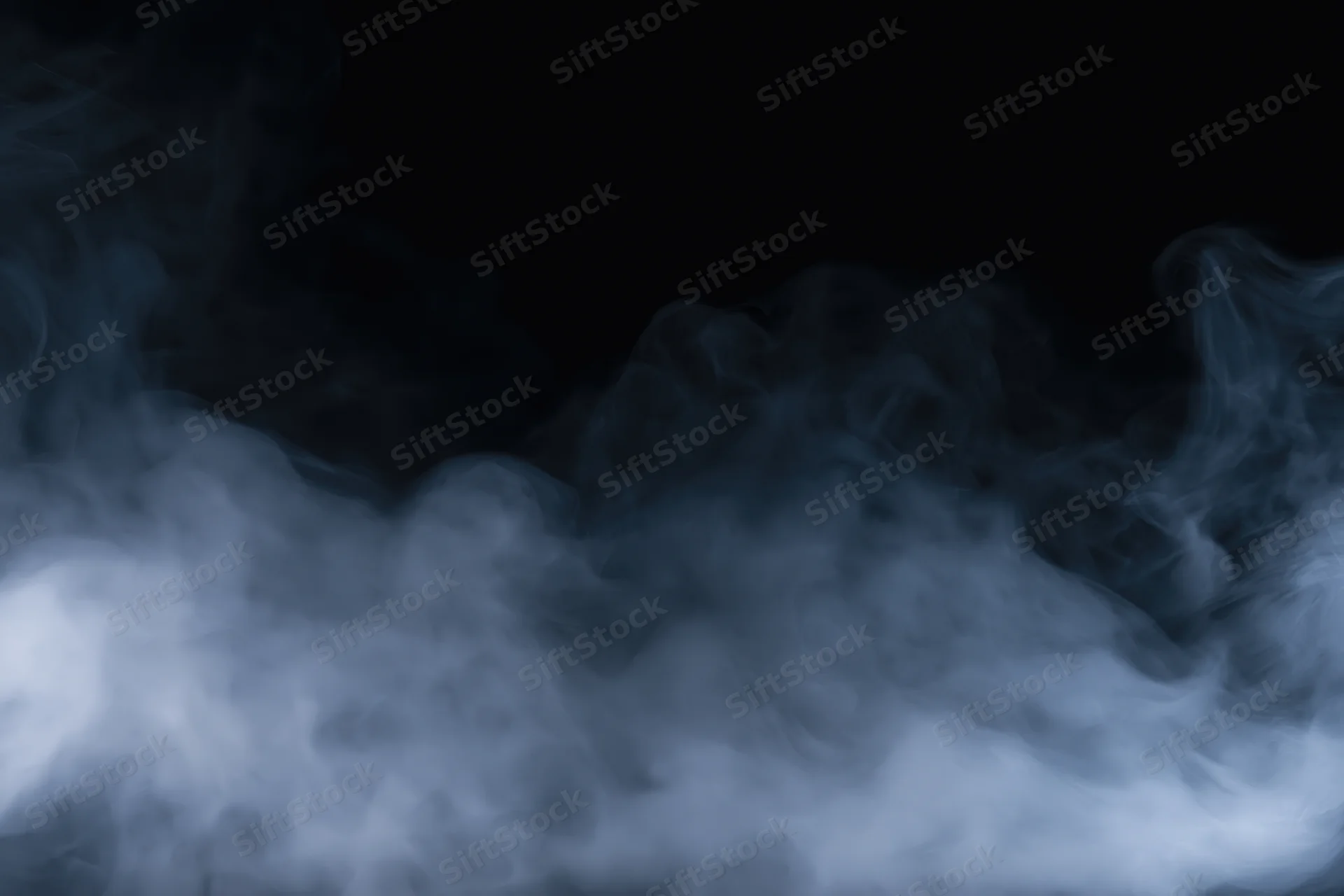 Wisps of white and grey smoke drifting across a dark background