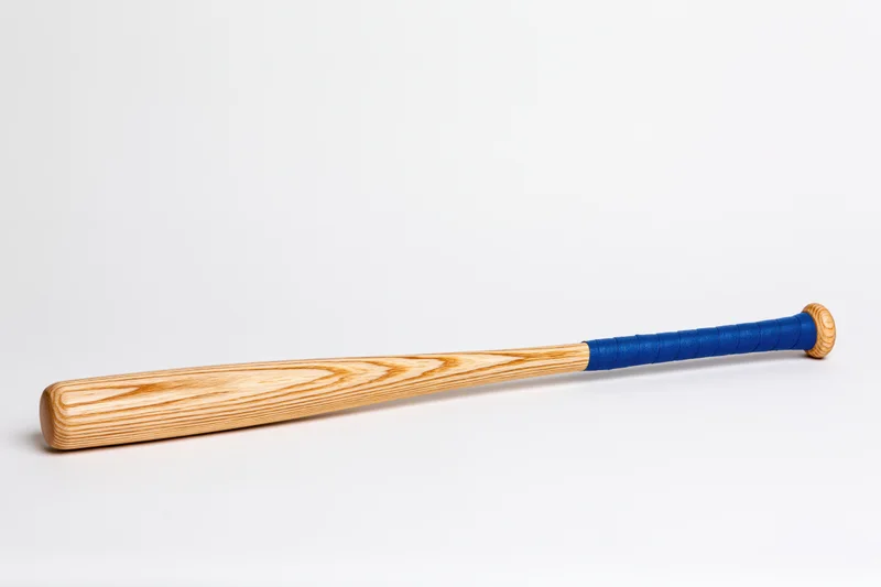 Wooden baseball bat lying diagonally on white background
