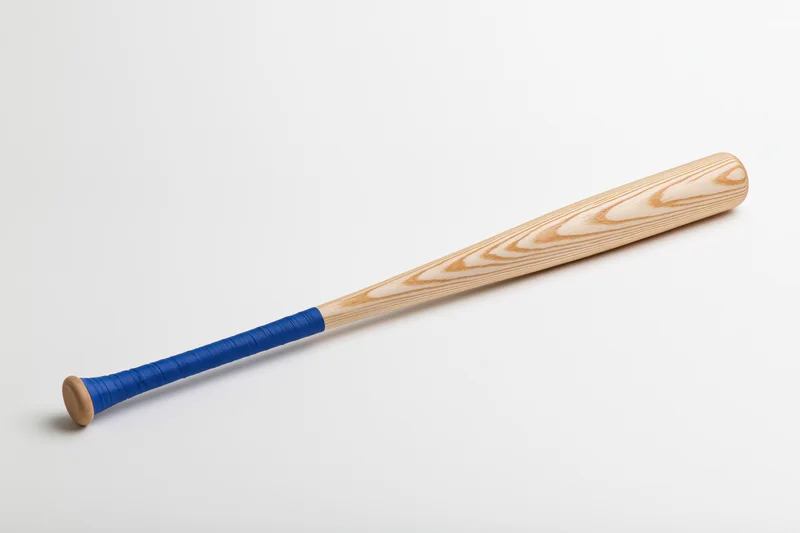 Wooden baseball bat with blue taped handle lying diagonally on plain white background