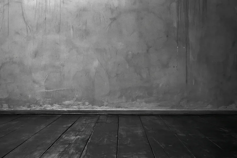 Empty industrial room with bare concrete wall and worn wooden floor
