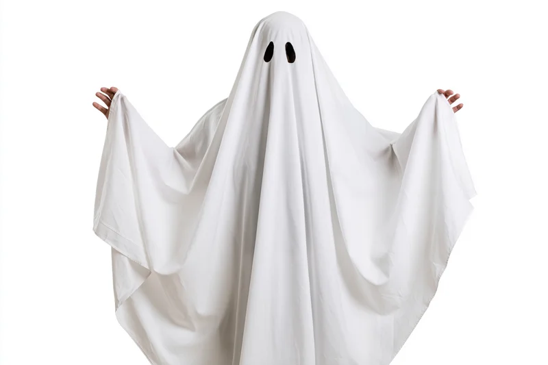 Person in white sheet ghost costume with black eye holes, arms raised, isolated on white