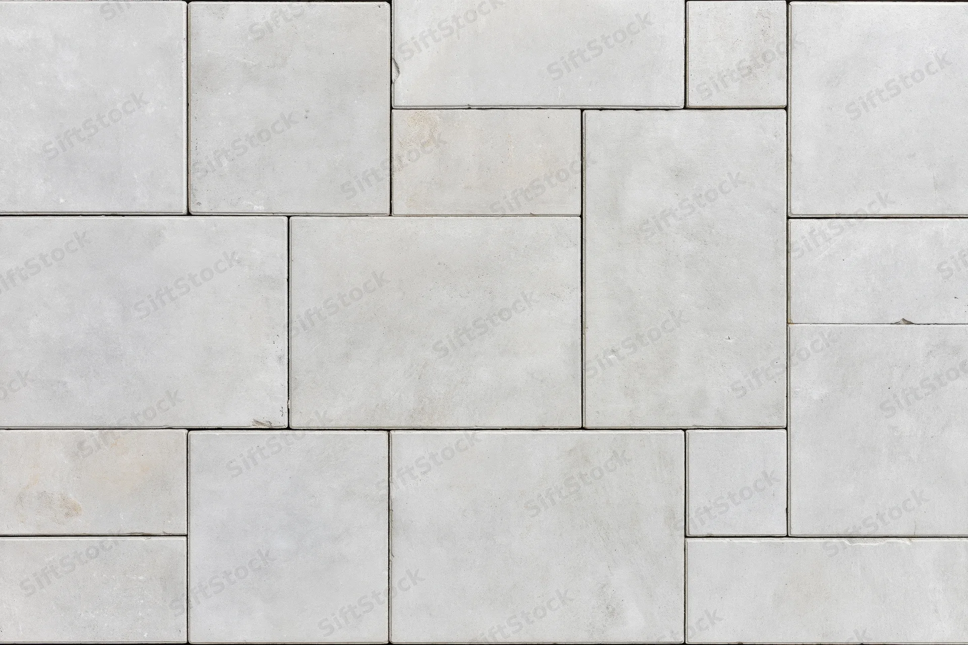 Close-up of concrete pavers arranged in a herringbone pattern for outdoor flooring