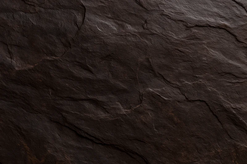 Close-up of dark brown slate stone surface with natural cracks and layered texture