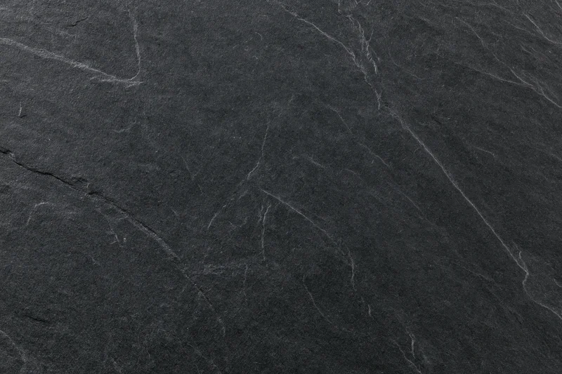 Close-up of dark slate stone surface with natural veins and cracks