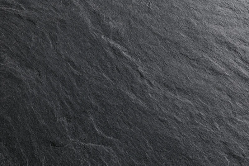 Close-up of dark slate stone surface with natural texture and veining