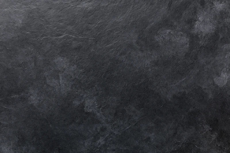Close-up of dark slate stone surface with natural texture and veining