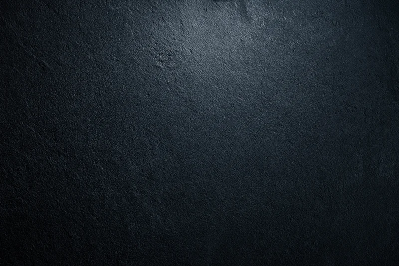 Dark textured concrete surface with spotlight effect and copyspace