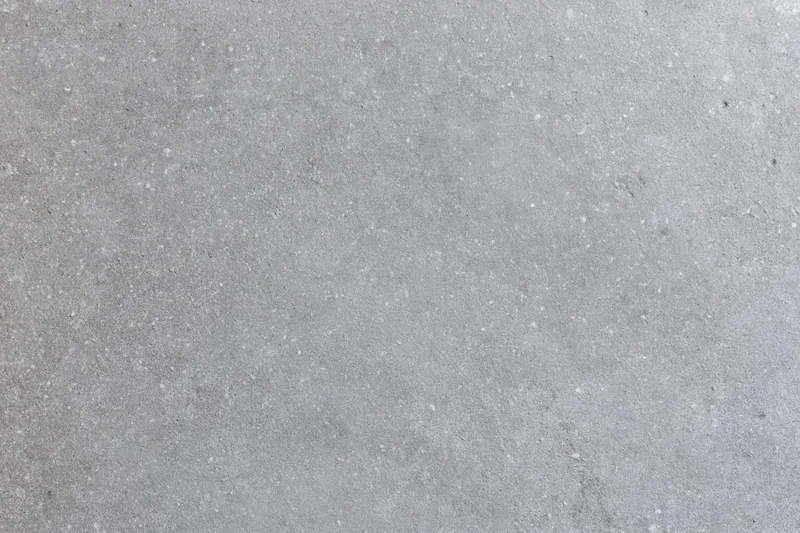 Close-up of rough gray concrete surface with speckled texture filling the frame