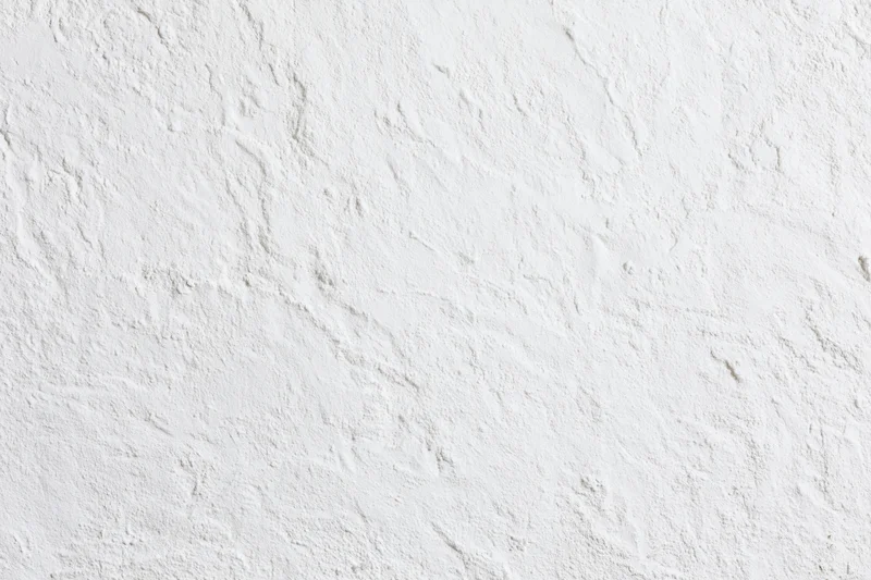 Close-up of rough white plaster wall surface filling the frame