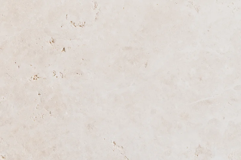 Close-up of travertine stone surface with natural veining and texture filling the frame