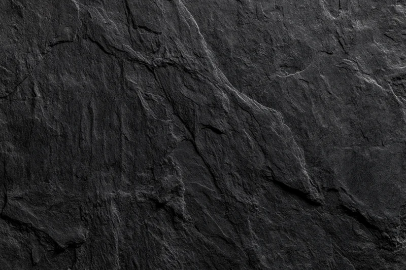 Close-up of dark slate rock surface with natural cracks and layers