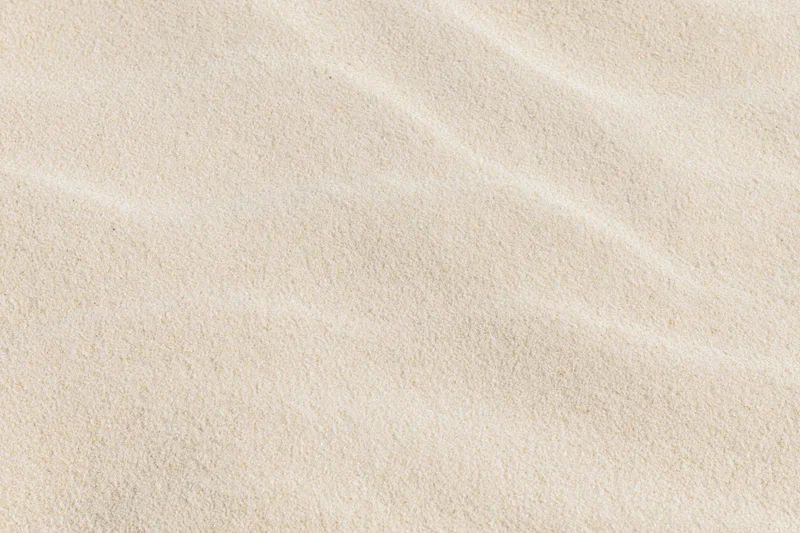 Close-up of dry beach sand with rippled texture filling the frame