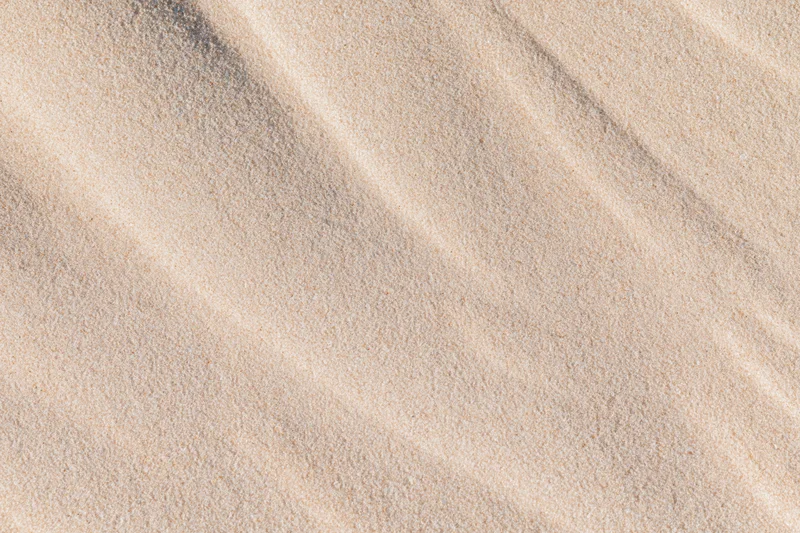 Close-up of dry beach sand with rippled texture filling the frame