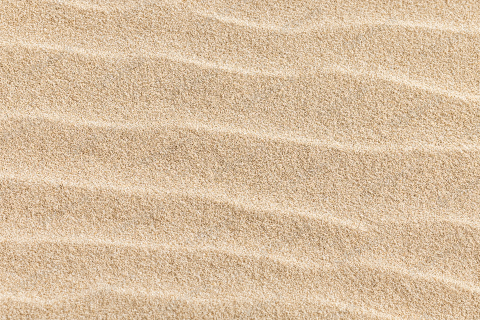 Close-up of rippled dry beach sand surface in flat lay arrangement