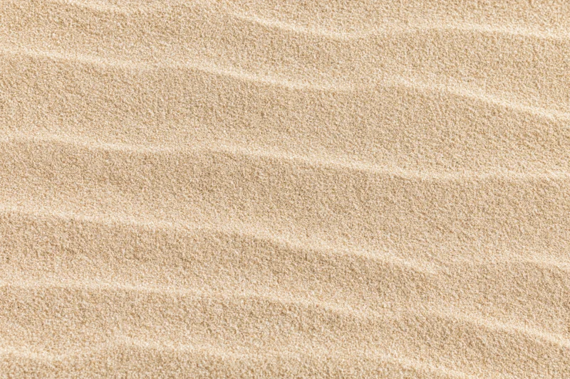 Close-up of rippled dry beach sand surface in flat lay arrangement