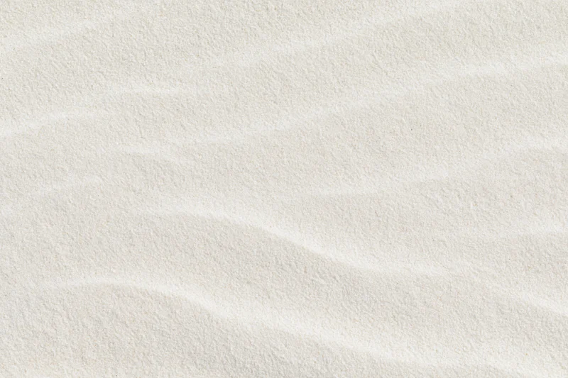 Close-up of fine white sand with rippled texture filling the frame