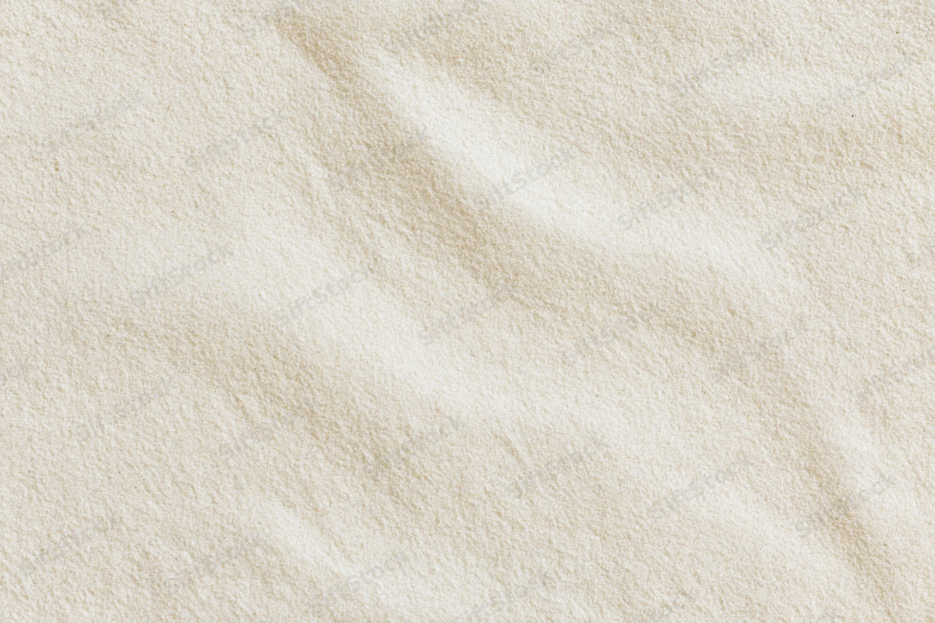 Close-up of fine beach sand surface with natural texture and subtle ripples