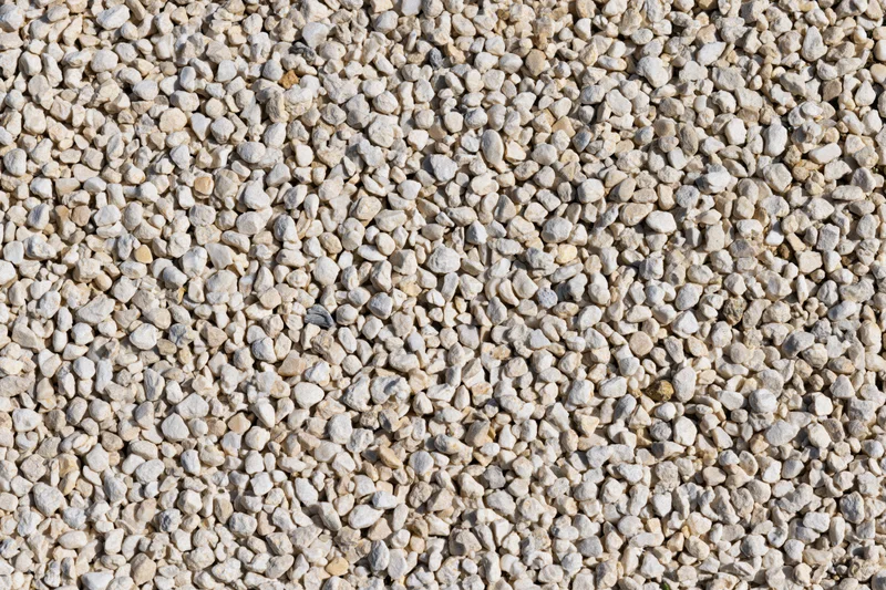 Close-up of fine gravel and small pebbles spread evenly across a flat surface