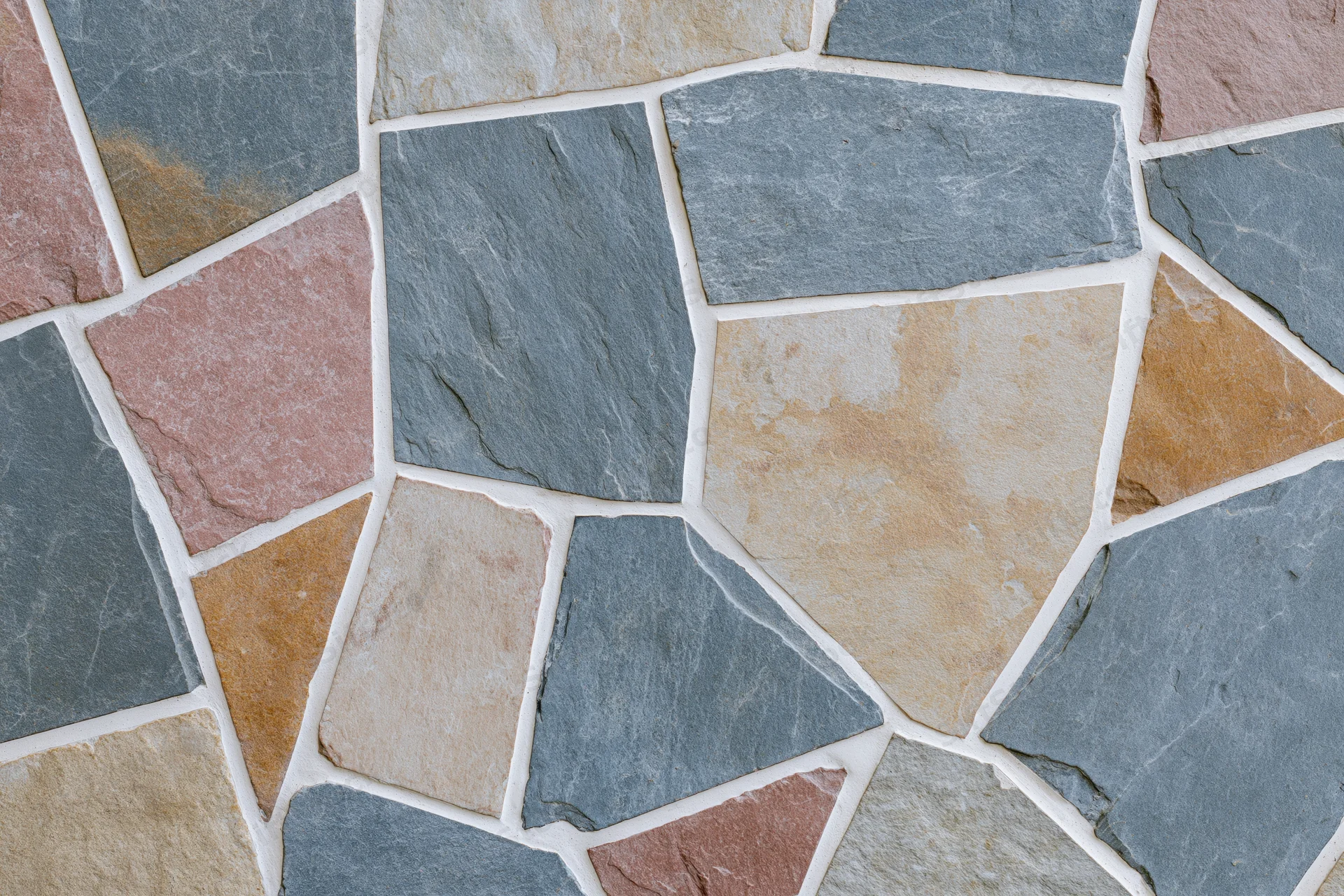 Close-up of irregular broken stone tile mosaic surface with grout lines forming a pattern