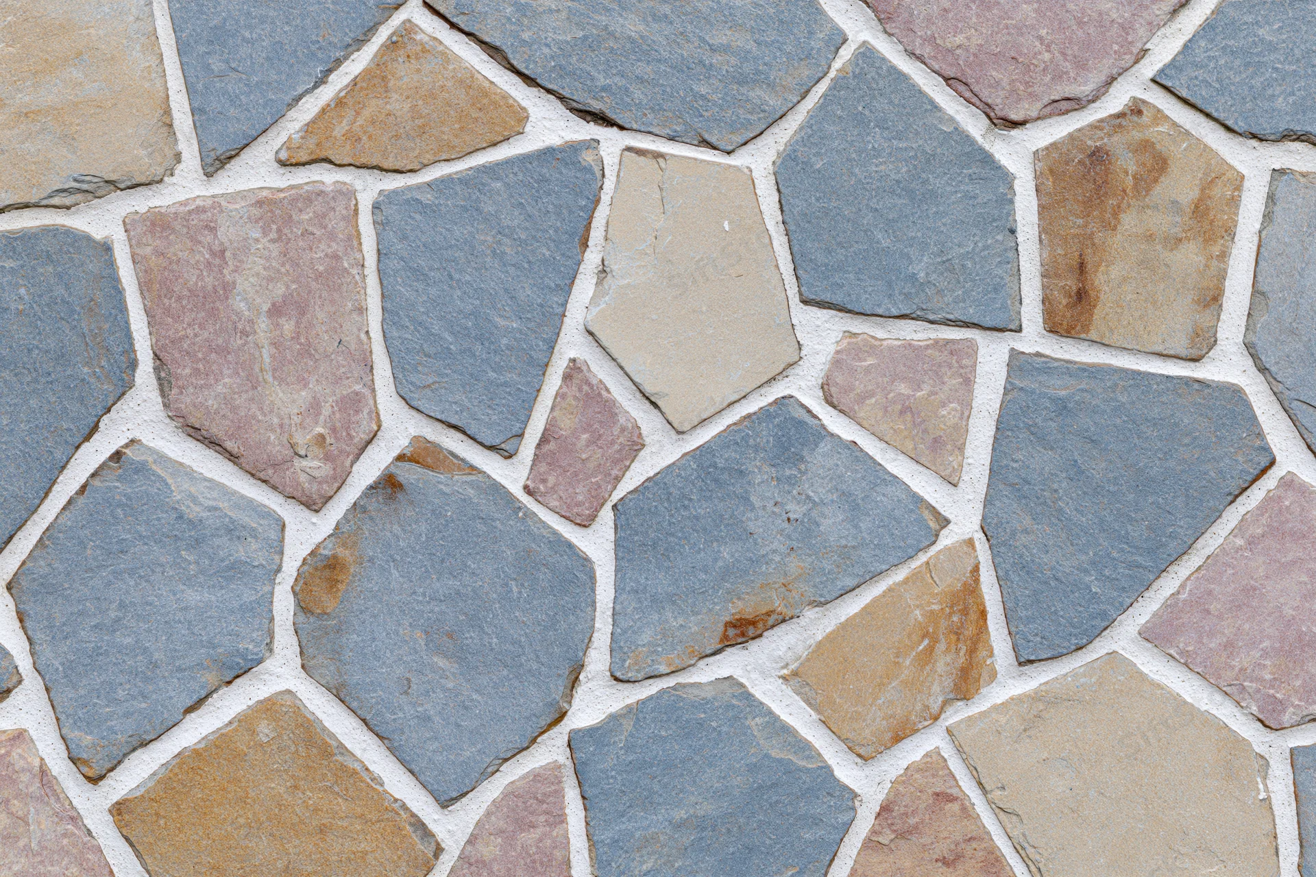 Close-up of irregular broken stone tile mosaic surface with grout lines
