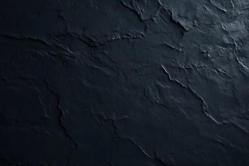 Close-up of rough dark stone or plaster surface with cracks and texture