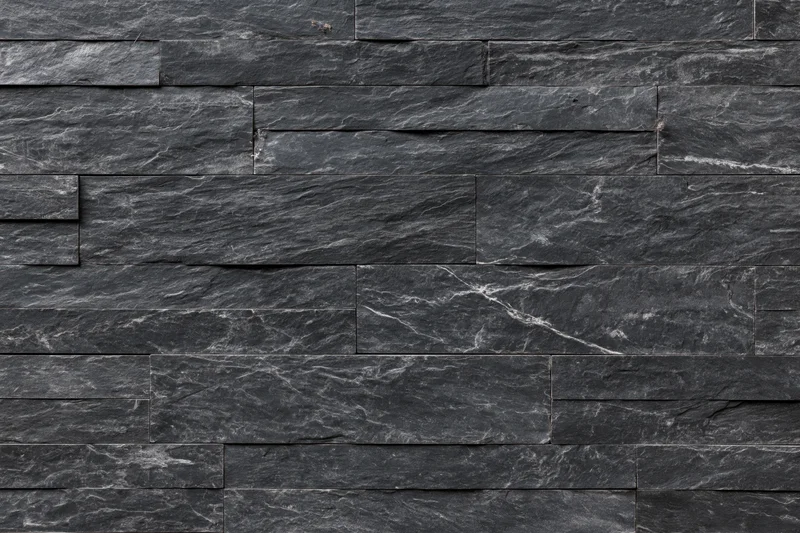 Stacked slate stone tile panels arranged in horizontal rows on a wall surface