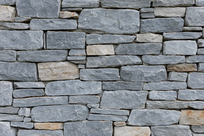 Close-up of a dry-stack cut stone wall filling the frame
