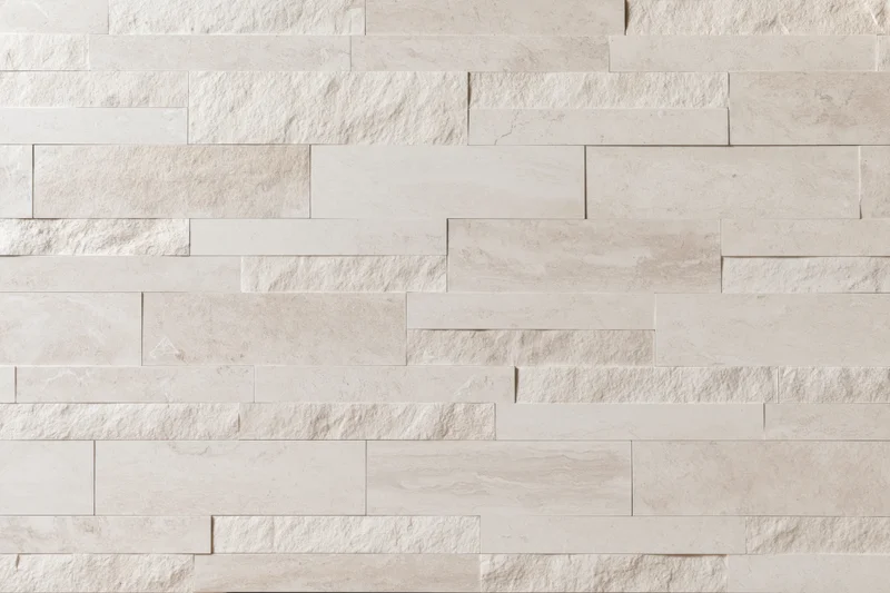 Close-up of a modern stacked stone tile wall with beige and cream rectangular tiles arranged horizontally