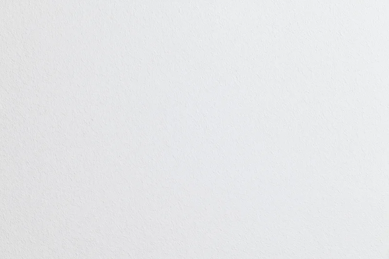 Close-up of a plain white textured wall surface in an indoor setting
