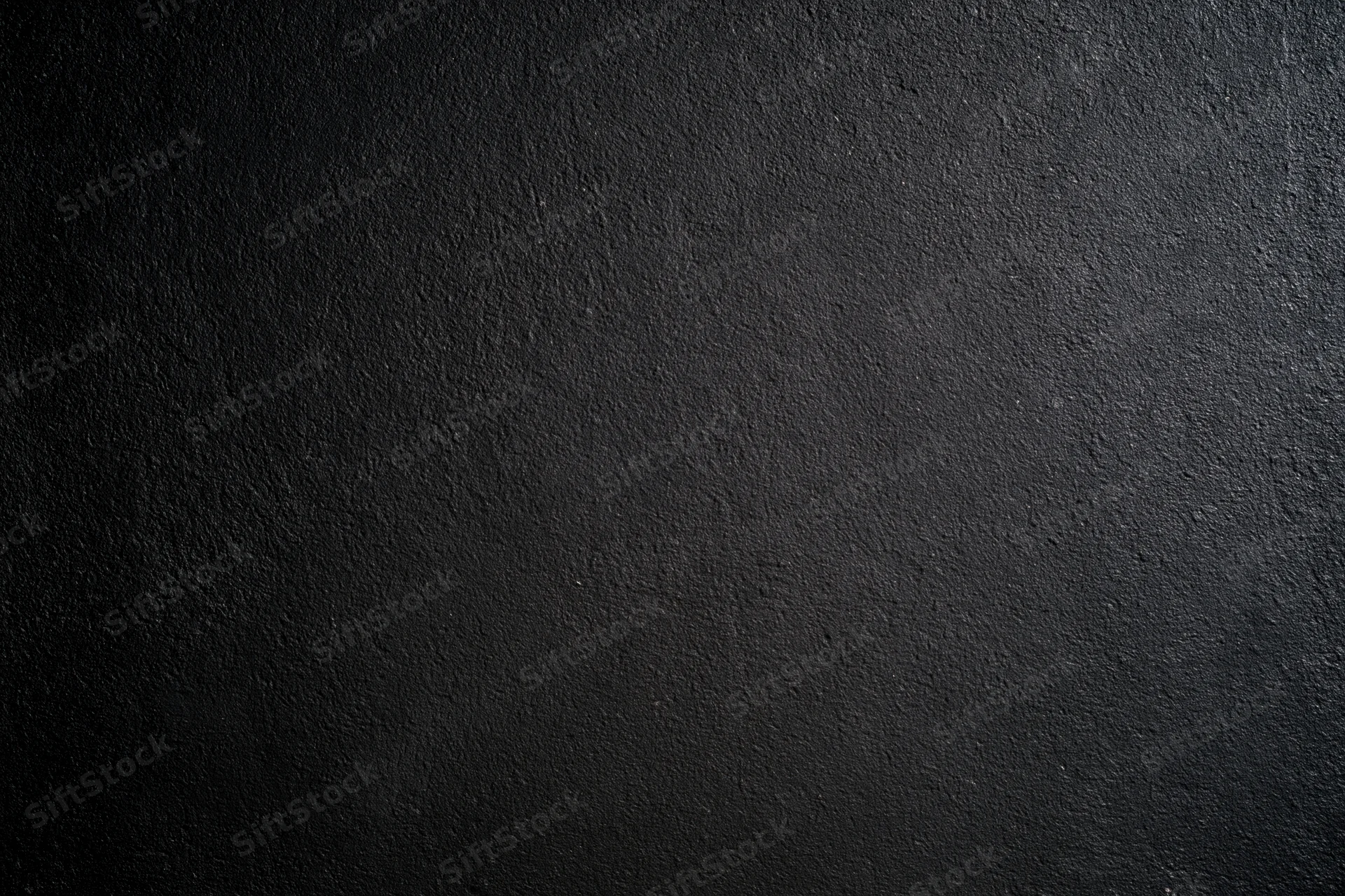 Close-up of a rough dark concrete wall surface