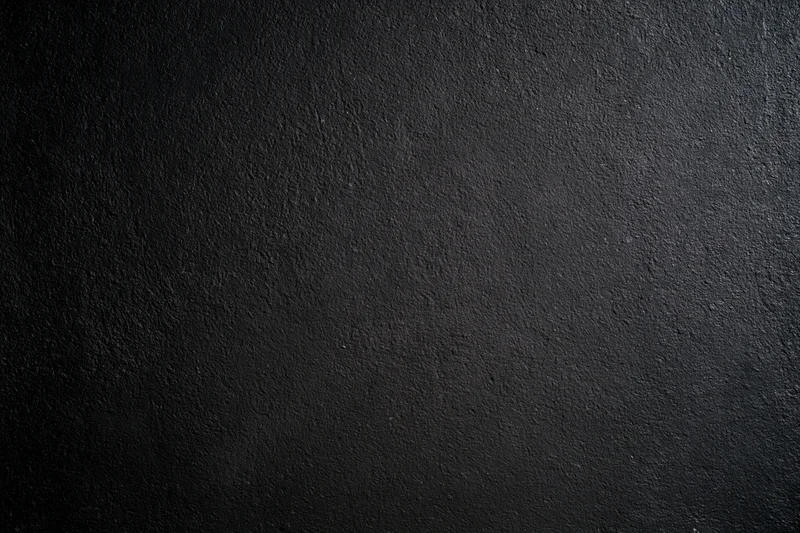 Close-up of a rough dark concrete wall surface