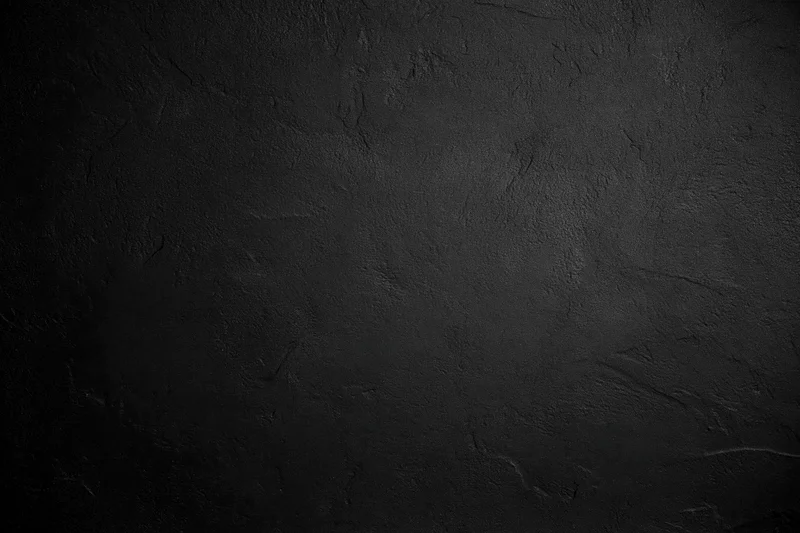 Dark rough concrete wall texture with subtle shadows and uneven surface