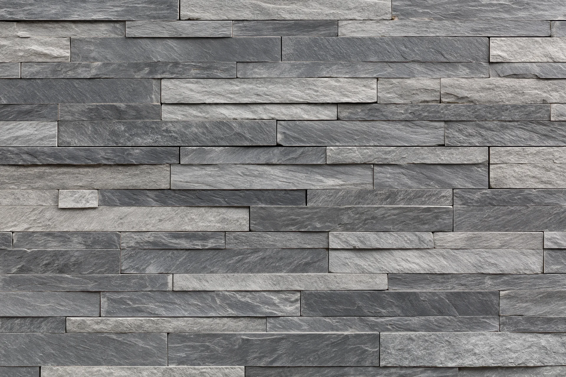 Stacked slate stone wall with horizontal rectangular tiles forming a textured gray facade