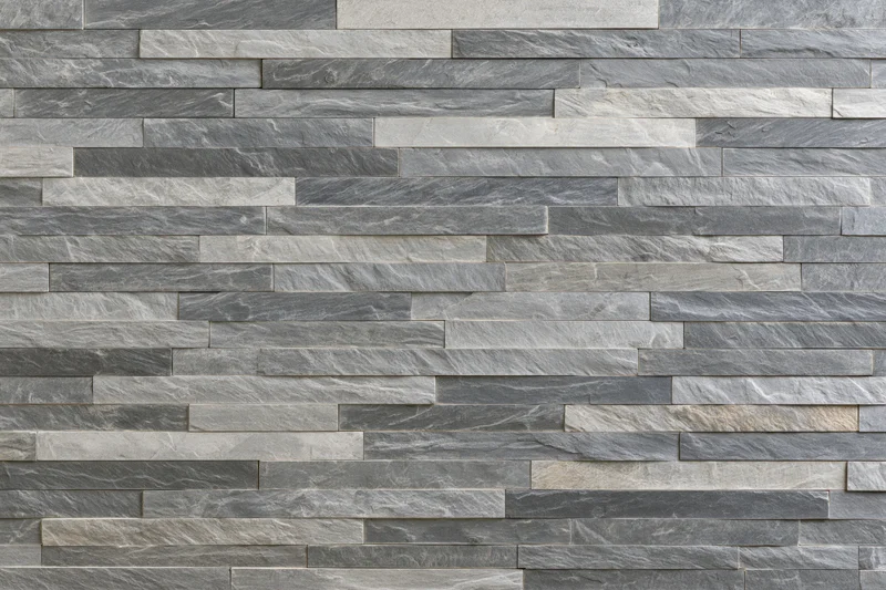 Horizontal stacked stone veneer wall with gray and beige slate tiles forming a textured surface