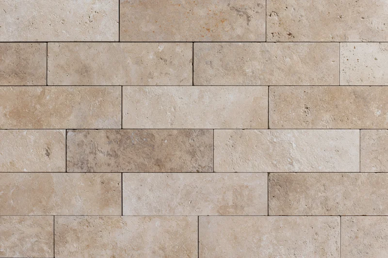 Close-up of travertine stone tiles arranged in rectangular pattern on a wall