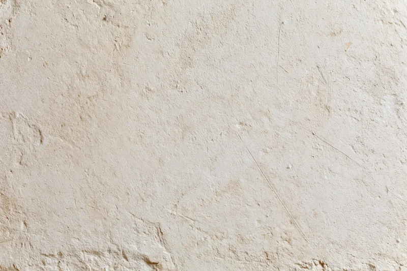 Close-up of a weathered plaster wall with textured surface and natural imperfections