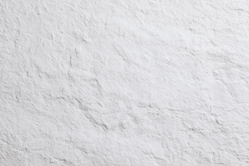 Close-up of white painted rough plaster wall surface