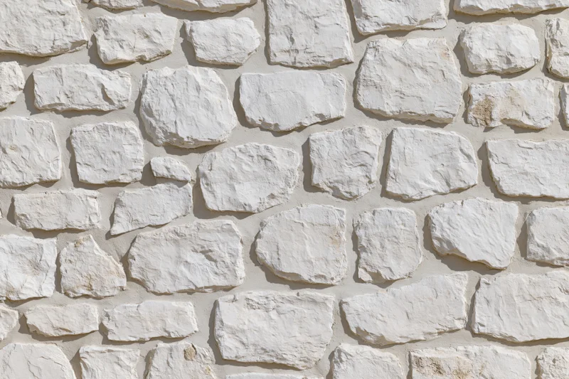 Close-up of whitewashed irregular stone wall surface with natural texture and mortar joints