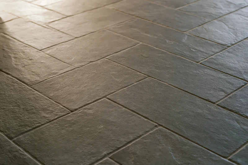 Herringbone-patterned stone tile flooring in a modern interior space